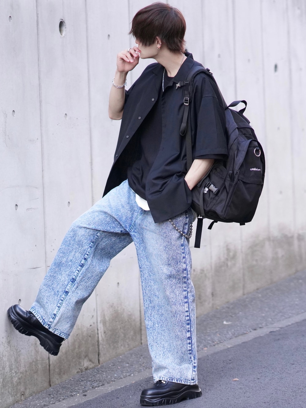 ホワイト系のタンクトップ、ブラック系のバックパック/リュック、ブルー系のデニムパンツを着用したメンズの春コーディネートの1枚目の写真
