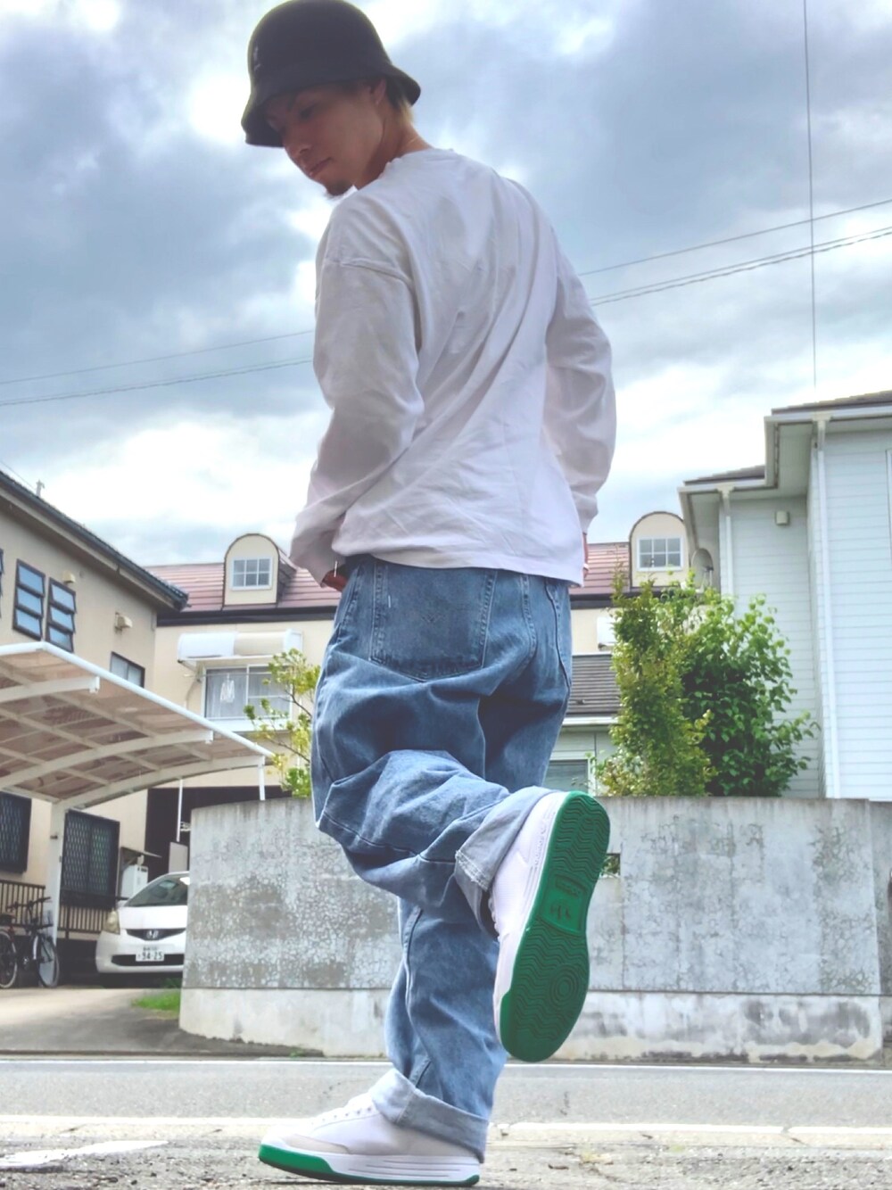 ホワイト系のTシャツ/カットソー、ブルー系のデニムパンツ、ホワイト系のスニーカーを着用したメンズの秋コーディネートの1枚目の写真