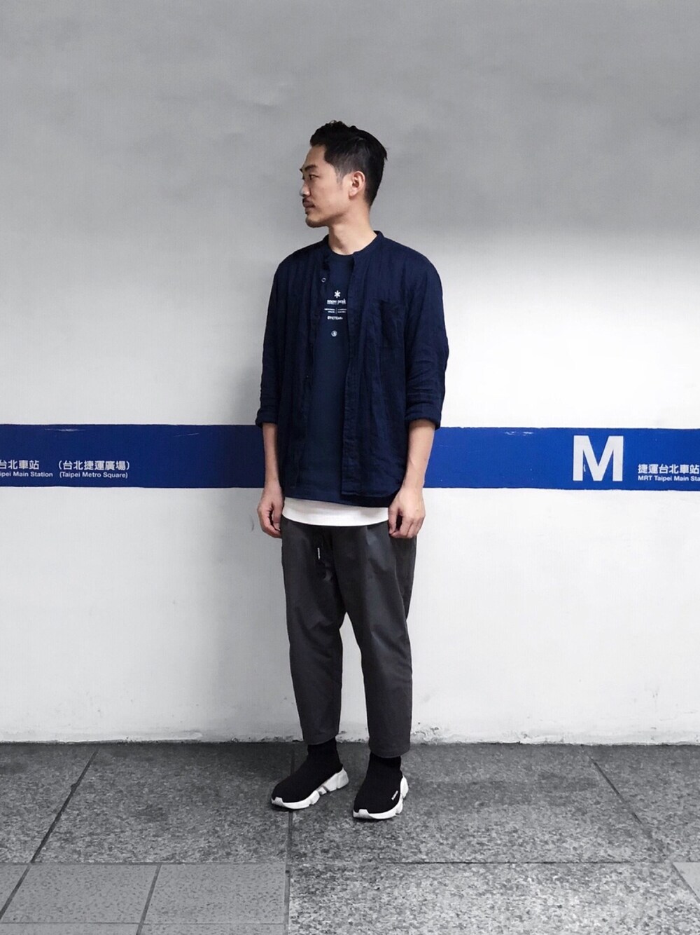 グレー系のチノパンツ、ブラック系のシューズ、ブルー系のTシャツ/カットソーを着用したメンズの秋コーディネートの1枚目の写真