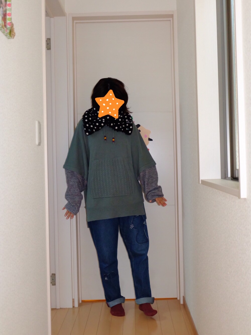 グレー系のニット/セーター、ブルー系のデニムパンツ、ブラック系のネックウォーマー/スヌードを着用したレディースの冬コーディネートの1枚目の写真