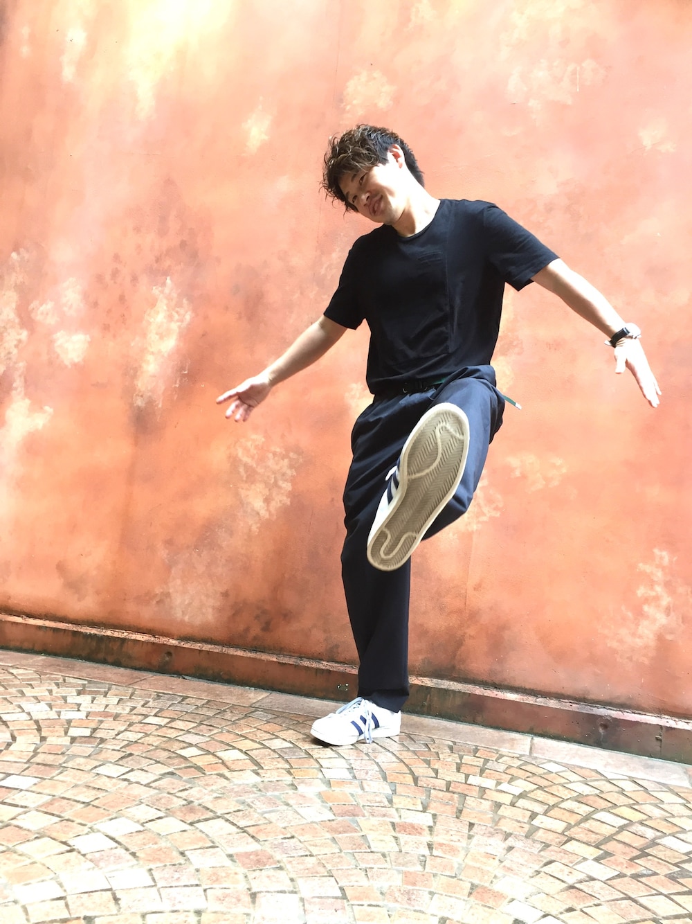 ホワイト系のスニーカー、グレー系のスラックス、ブラック系のTシャツ/カットソーを着用したメンズの夏コーディネートの1枚目の写真