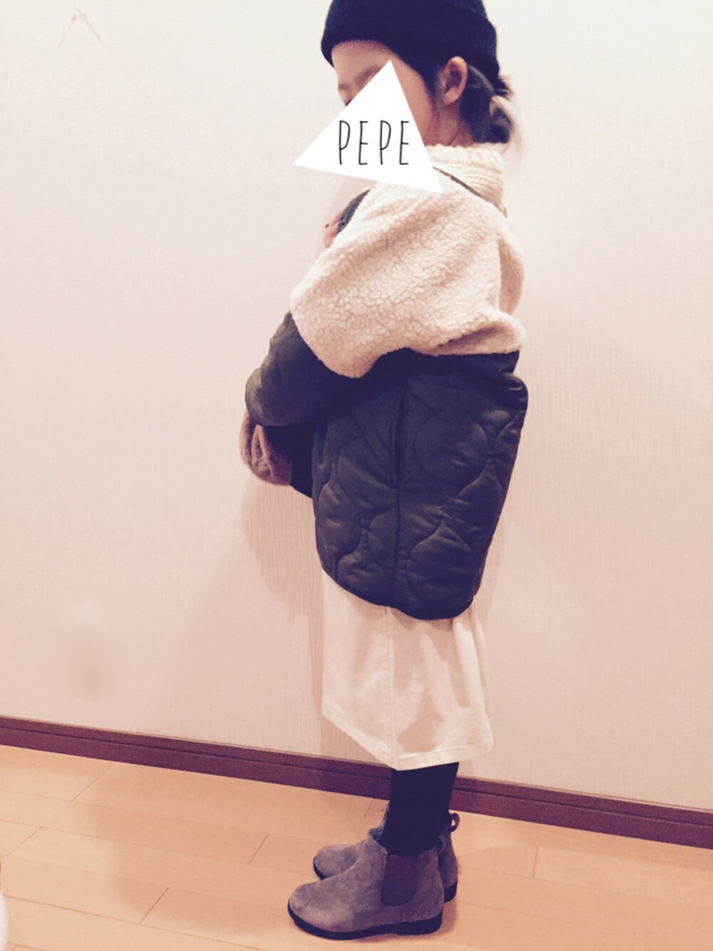 グリーン系のダウンジャケット/コート、ホワイト系のニット/セーター、ホワイト系のスカートを着用したキッズの冬コーディネートの1枚目の写真