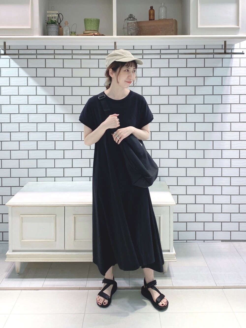 ブラック系のワンピースを着用したレディースの夏コーディネートの1枚目の写真