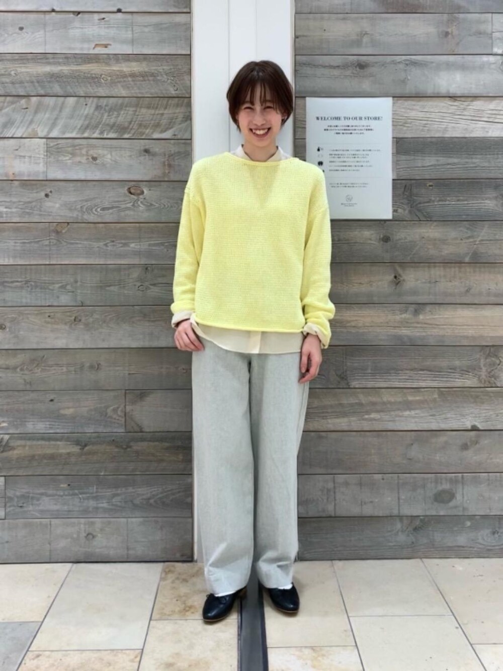 ブルー系のデニムパンツ、イエロー系のニット/セーター、ベージュ系のシャツ/ブラウスを着用したレディースの冬コーディネートの1枚目の写真