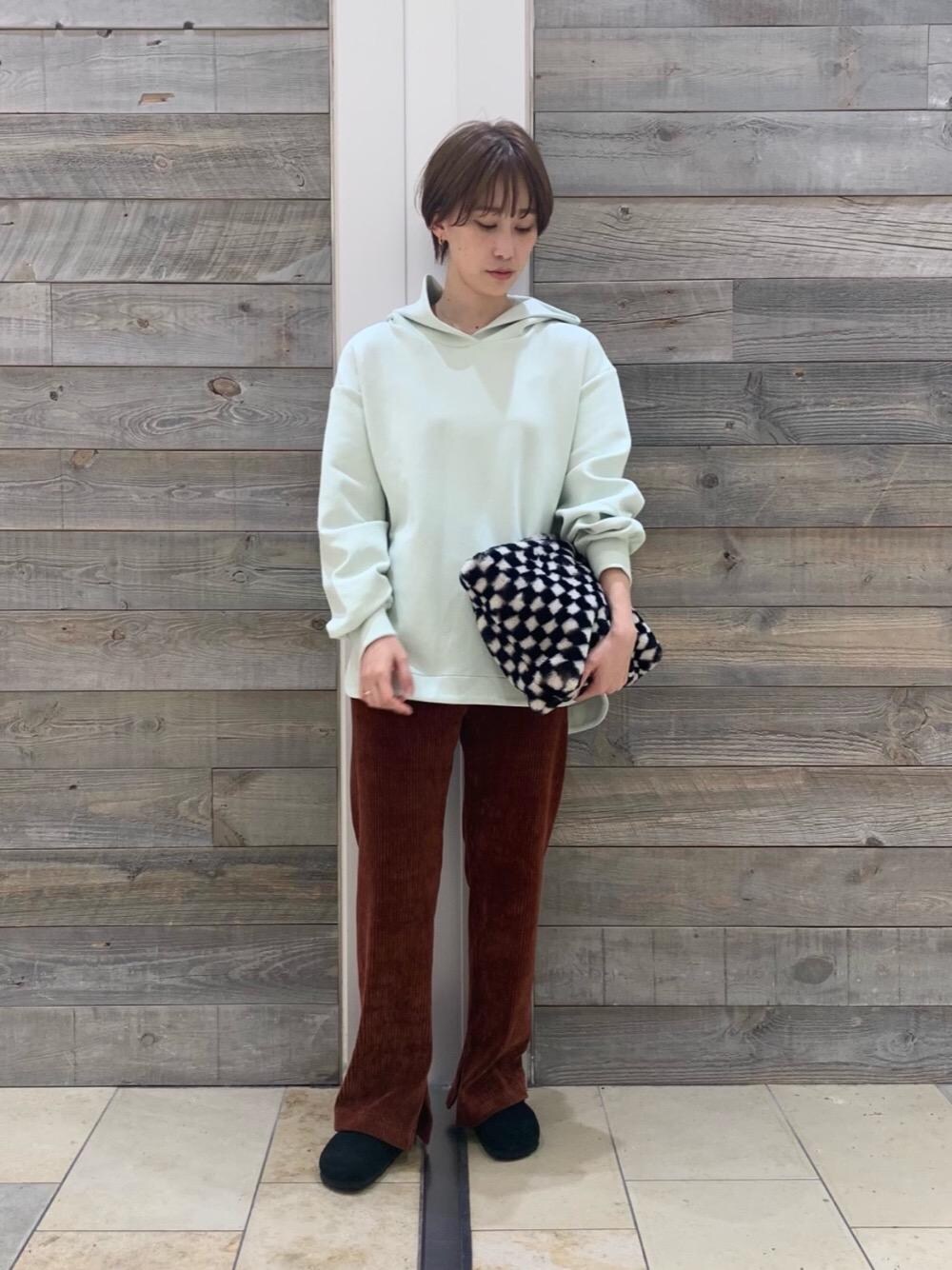 ブラック系のショルダーバッグ、ブラック系のサンダル、グリーン系のパーカーを着用したレディースの秋コーディネートの1枚目の写真