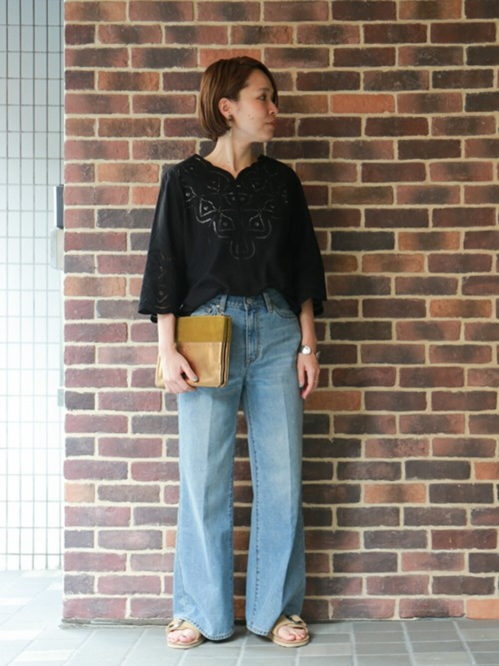 「クラッチバッグ、刺繍、デニムパンツ、サンダル、大人コーデ、きれいめカジュアル、ラフスタイル、シンプルコーデ、刺繍ブラウス、ワイドデニム」｜「NOMBRE IMPAIRのカットワークレース Ｖネックフレアスリーブブラウス（シャツ/ブラウス、ブラック系）」を使った、RolladeX STAFFさん（レディース・160cm）の春コーディネートの1枚目の写真