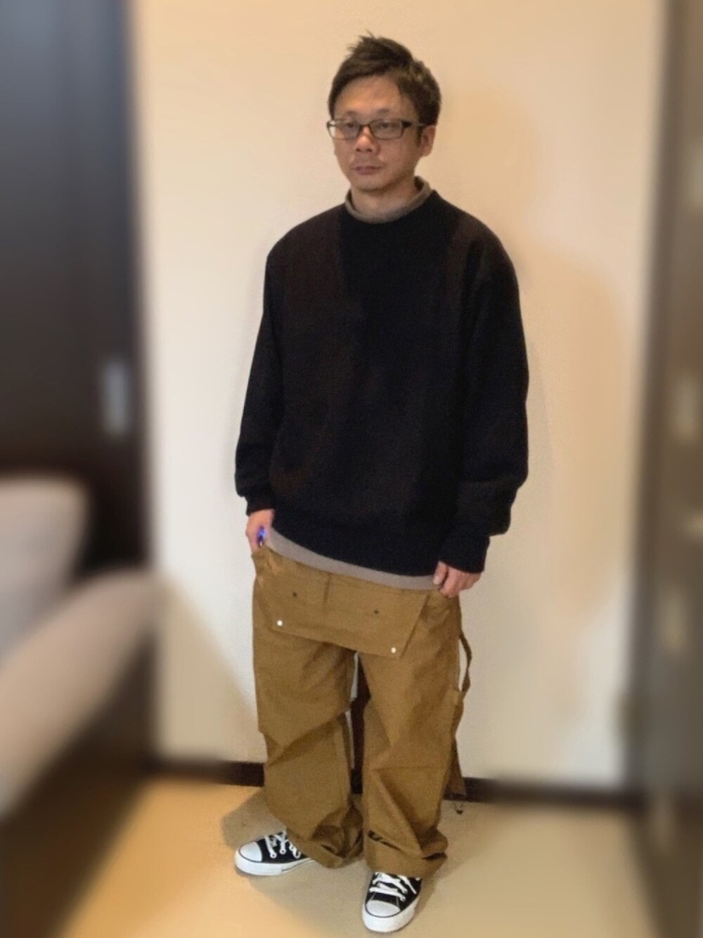 ブラック系のスウェット、ベージュ系のTシャツ/カットソー、ブラウン系のサロペット/オーバーオールを着用したメンズの秋コーディネートの1枚目の写真