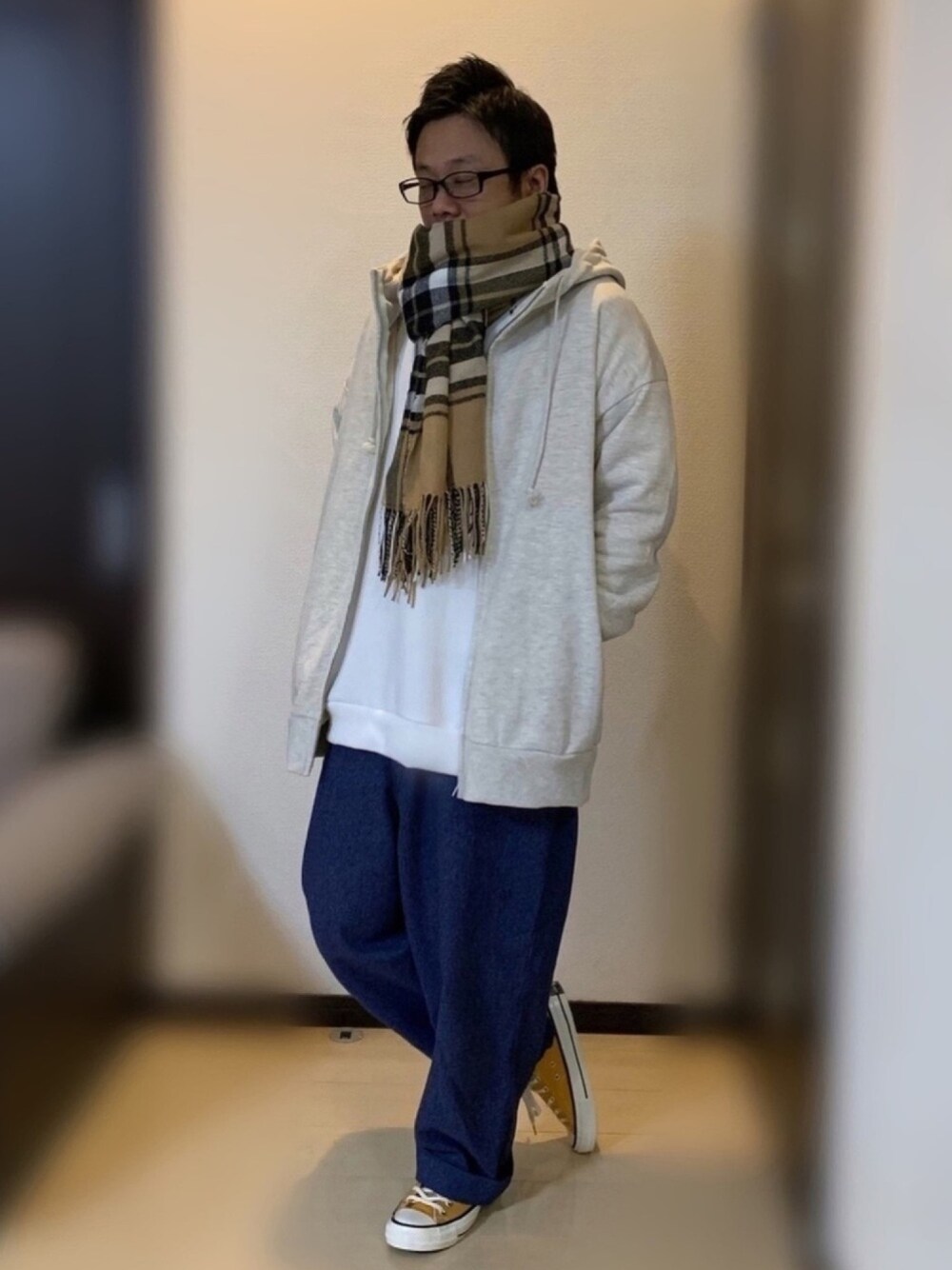 ベージュ系のパーカー、ブルー系のデニムパンツ、ホワイト系のスウェットを着用したメンズの秋コーディネートの1枚目の写真