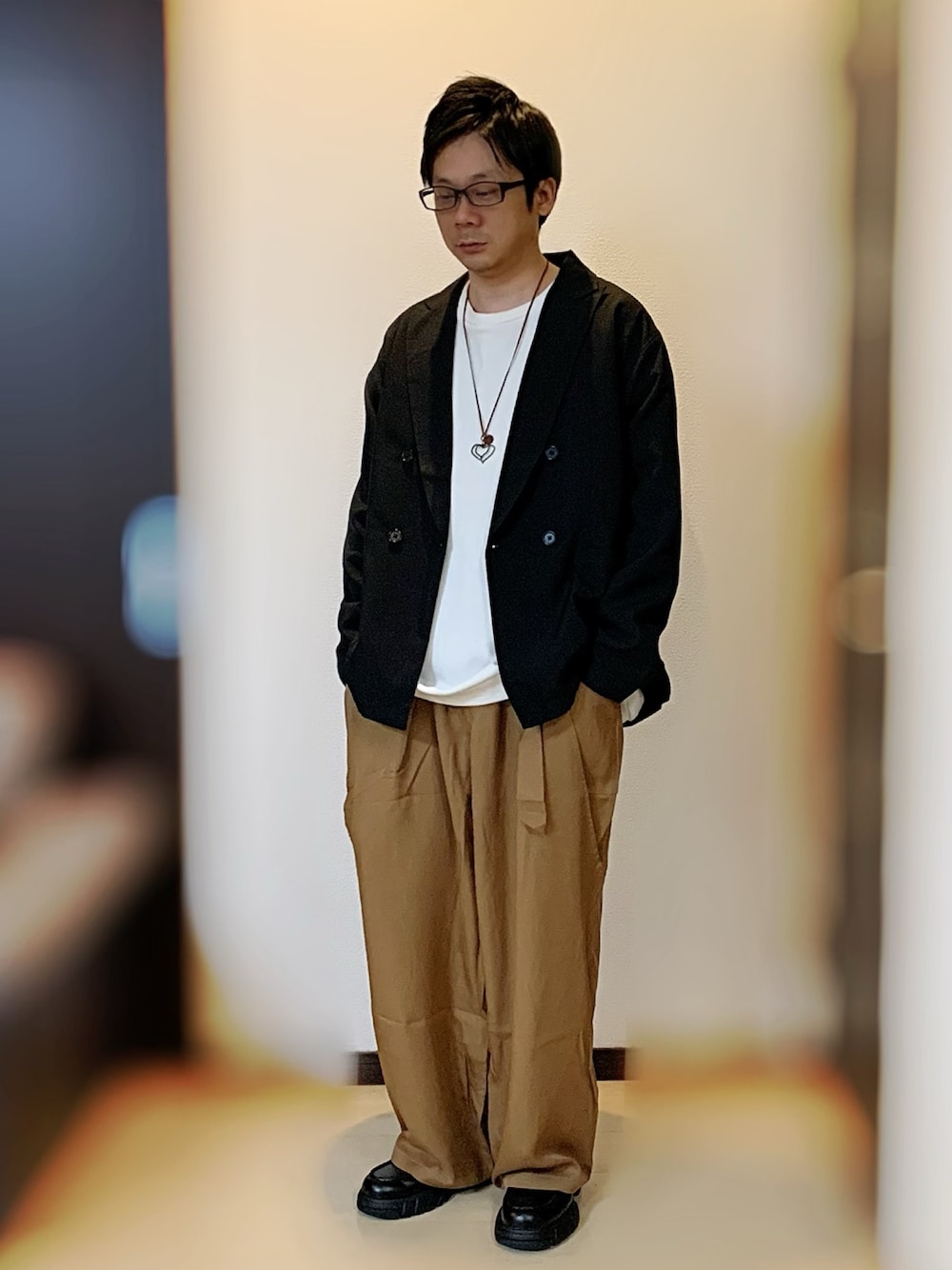 ブラック系のテーラードジャケット、ホワイト系のスウェット、ブラウン系のその他パンツを着用したメンズの春コーディネートの1枚目の写真