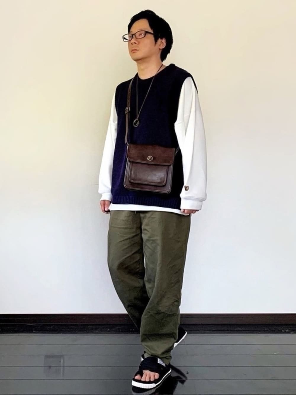 ホワイト系のスウェット、ブルー系のベスト、グリーン系のその他パンツを着用したメンズの春コーディネートの1枚目の写真