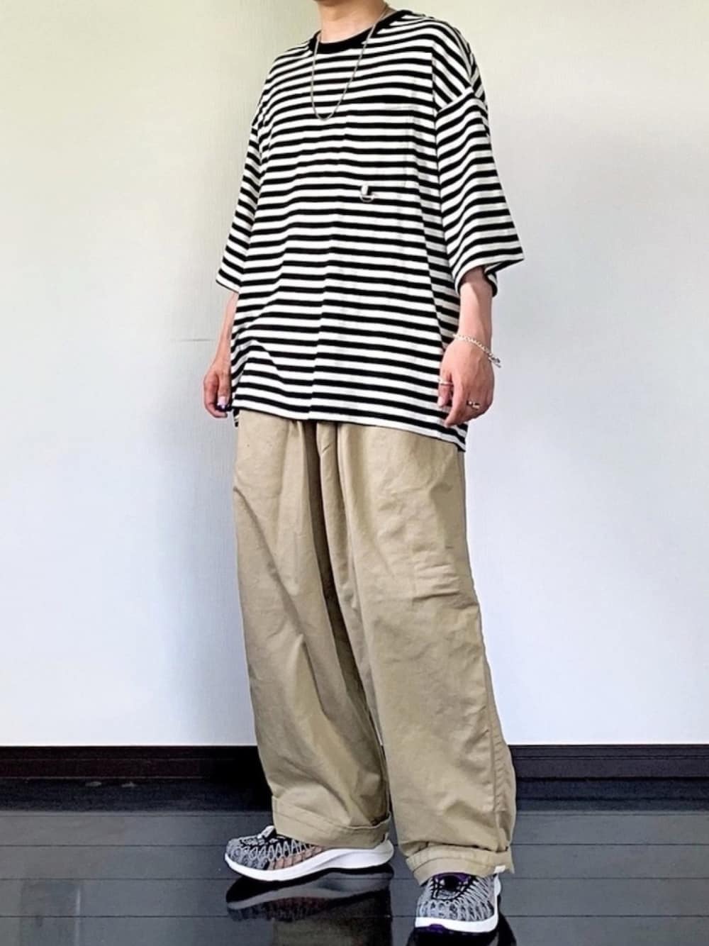 ホワイト系のTシャツ/カットソー、ベージュ系のチノパンツ、グレー系のスニーカーを着用したメンズの夏コーディネートの1枚目の写真