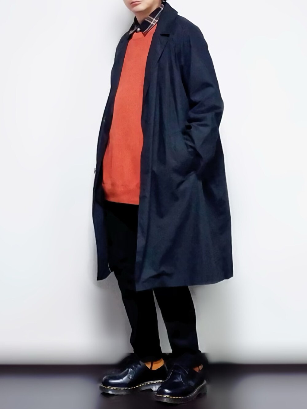 ブラック系のシャツ/ブラウス、オレンジ系のベスト、ブラック系のトレンチコートを着用したメンズの秋コーディネートの1枚目の写真