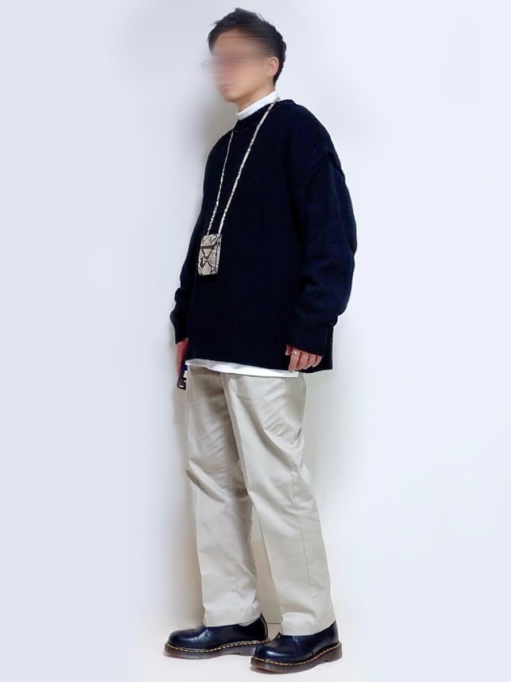 ブラック系のニット/セーター、ホワイト系のTシャツ/カットソー、ホワイト系のその他パンツを着用したメンズの秋コーディネートの1枚目の写真