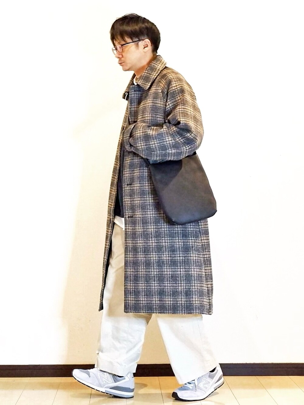 グレー系のステンカラーコート、ホワイト系のシャツ/ブラウス、ブルー系のTシャツ/カットソーを着用したメンズの冬コーディネートの1枚目の写真