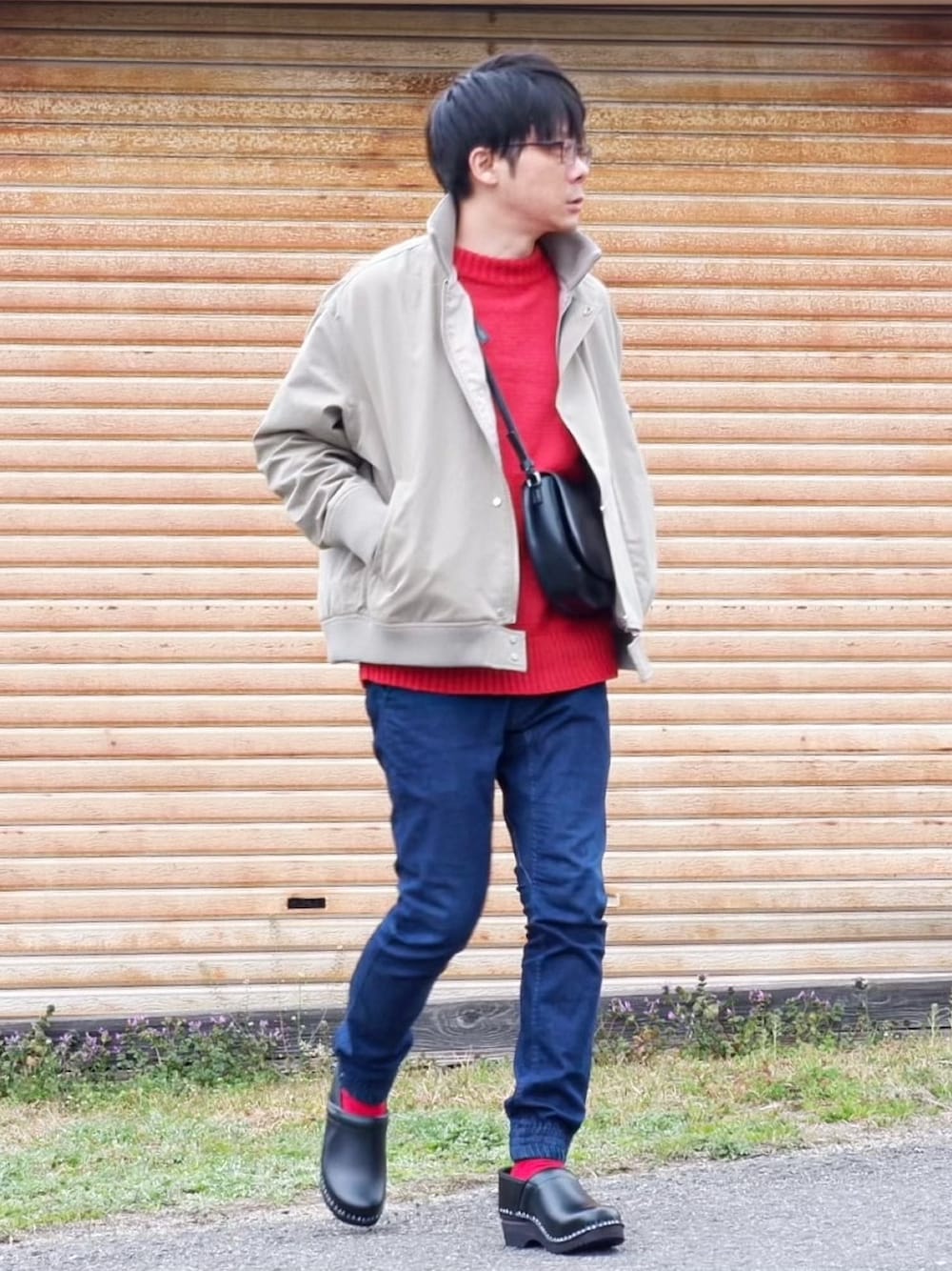 グリーン系のMA-1、レッド系のニット/セーター、ブルー系のデニムパンツを着用したメンズの春コーディネートの1枚目の写真