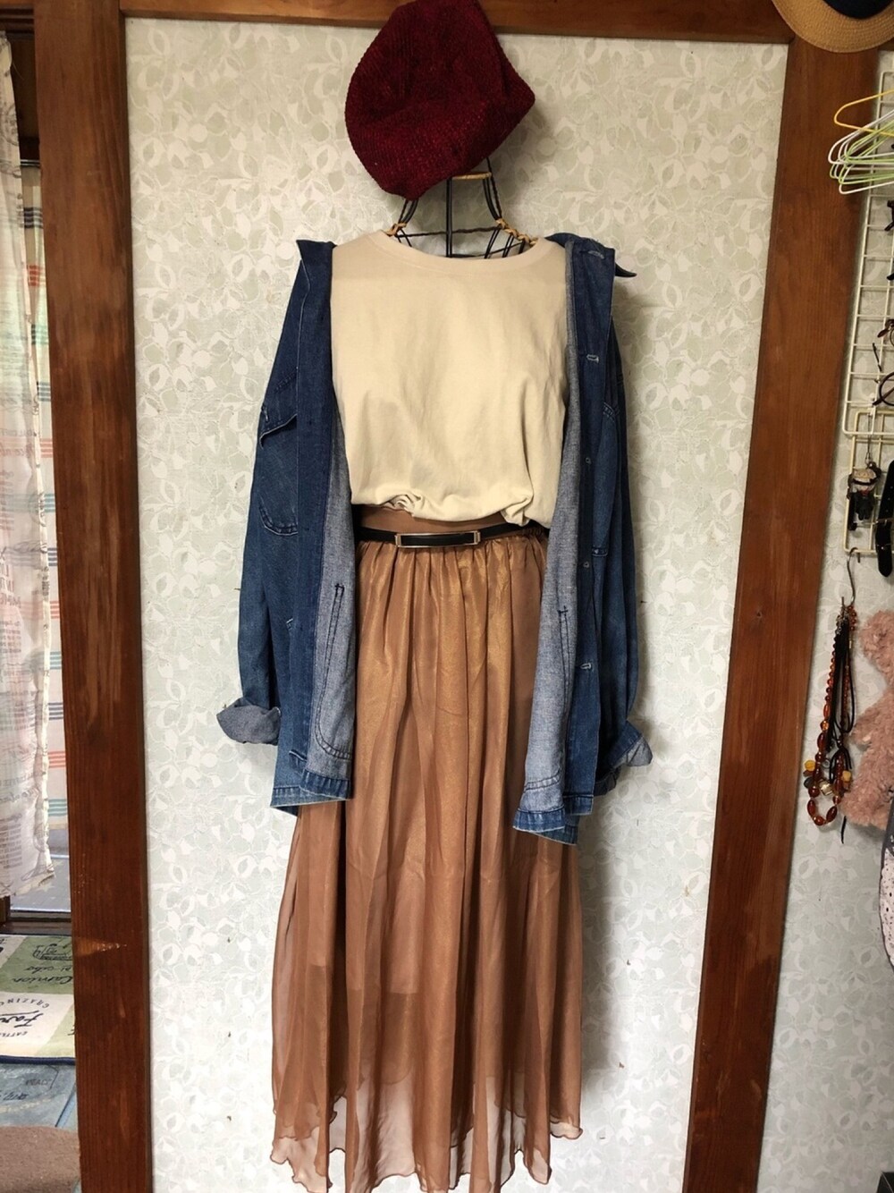 ブラウン系のスカート、ベージュ系のTシャツ/カットソー、ブルー系のデニムジャケットを着用したレディースの秋コーディネートの1枚目の写真