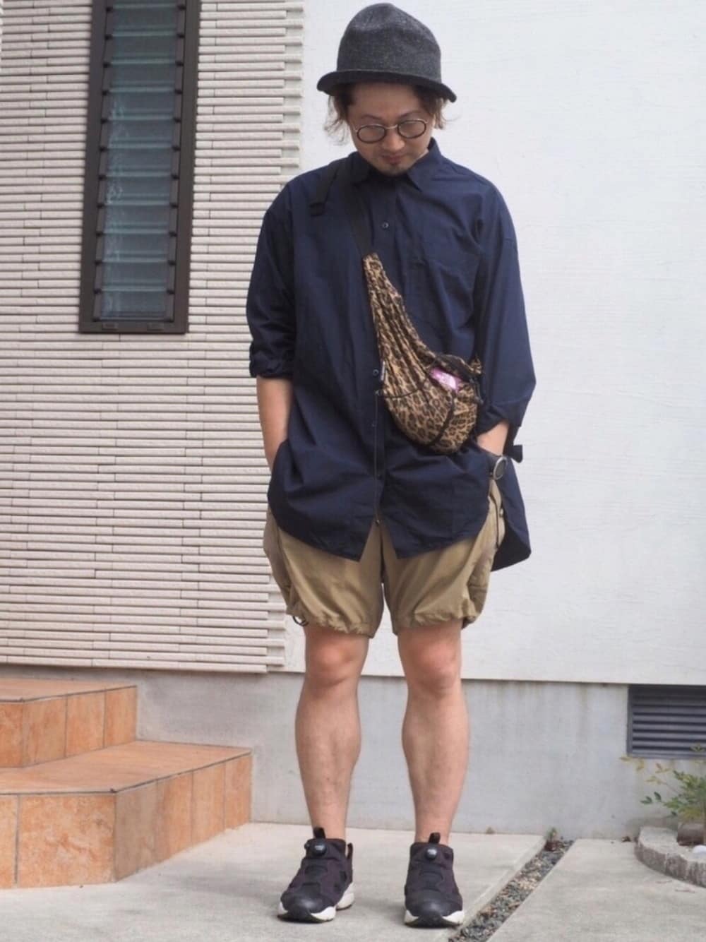 ブラック系のスニーカー、ベージュ系のその他パンツ、ブルー系のシャツ/ブラウスを着用したメンズの秋コーディネートの1枚目の写真