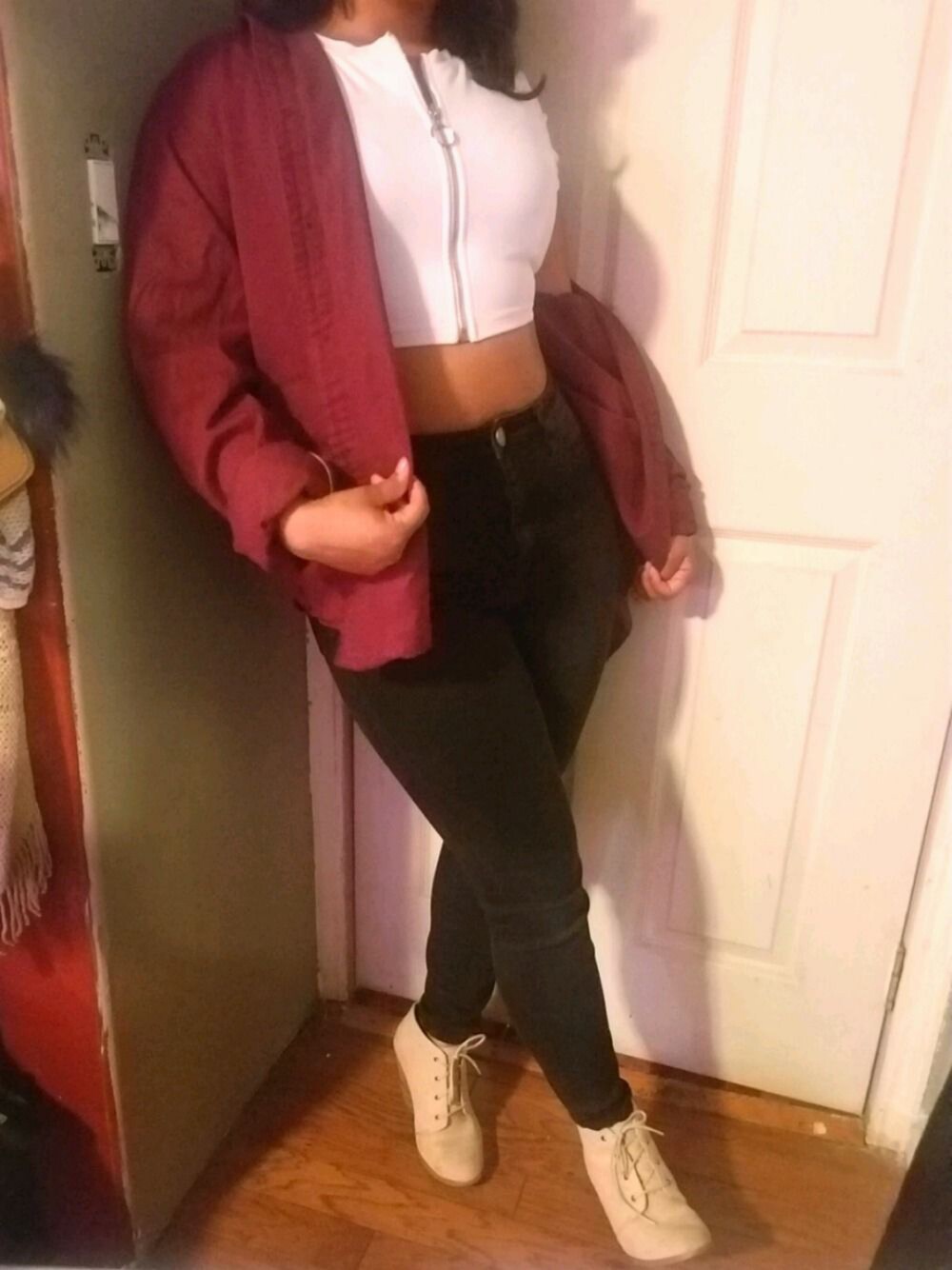 ブラック系のデニムパンツ、ベージュ系のブーツ、レッド系のトップスを着用したレディースの夏コーディネートの1枚目の写真