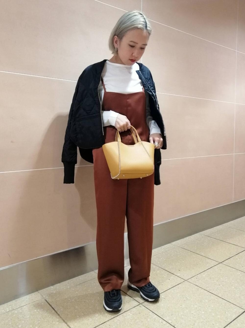 ブラック系のブルゾン、イエロー系のショルダーバッグ、ブラウン系のサロペット/オーバーオールを着用したレディースの冬コーディネートの1枚目の写真