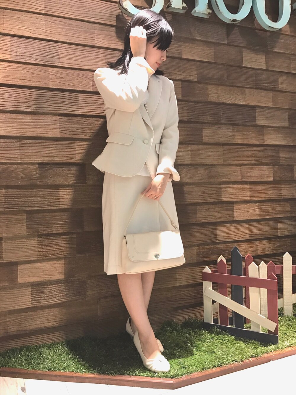 ベージュ系のパンプス、ベージュ系のショルダーバッグ、ベージュ系のスカートを着用したレディースの冬コーディネートの1枚目の写真