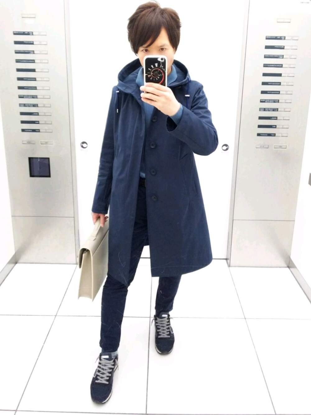 ブルー系のスニーカー、ブルー系のニット/セーター、ホワイト系のビジネスバッグを着用したメンズの冬コーディネートの1枚目の写真