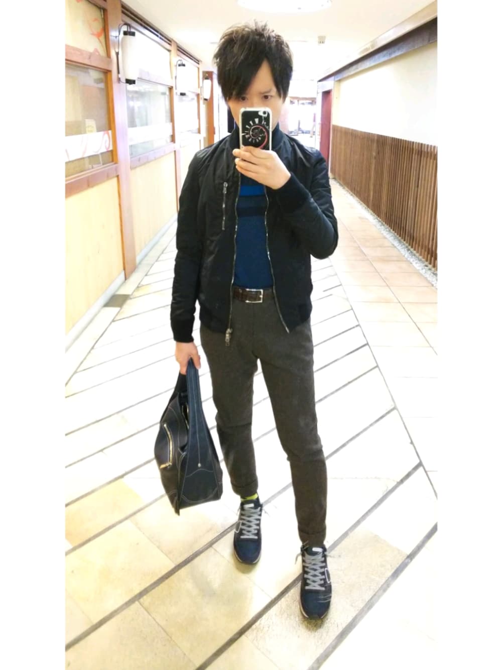 ブラウン系のスラックス、ブラック系のその他アウター、ブルー系のスニーカーを着用したメンズの春コーディネートの1枚目の写真