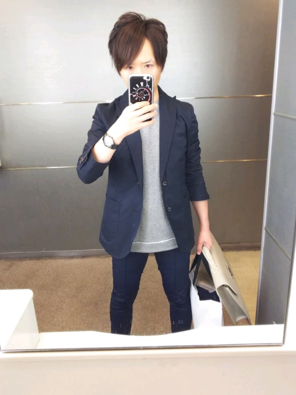 ブルー系のセットアップ、ブルー系のパンツ、ホワイト系のビジネスバッグを着用したメンズの春コーディネートの1枚目の写真