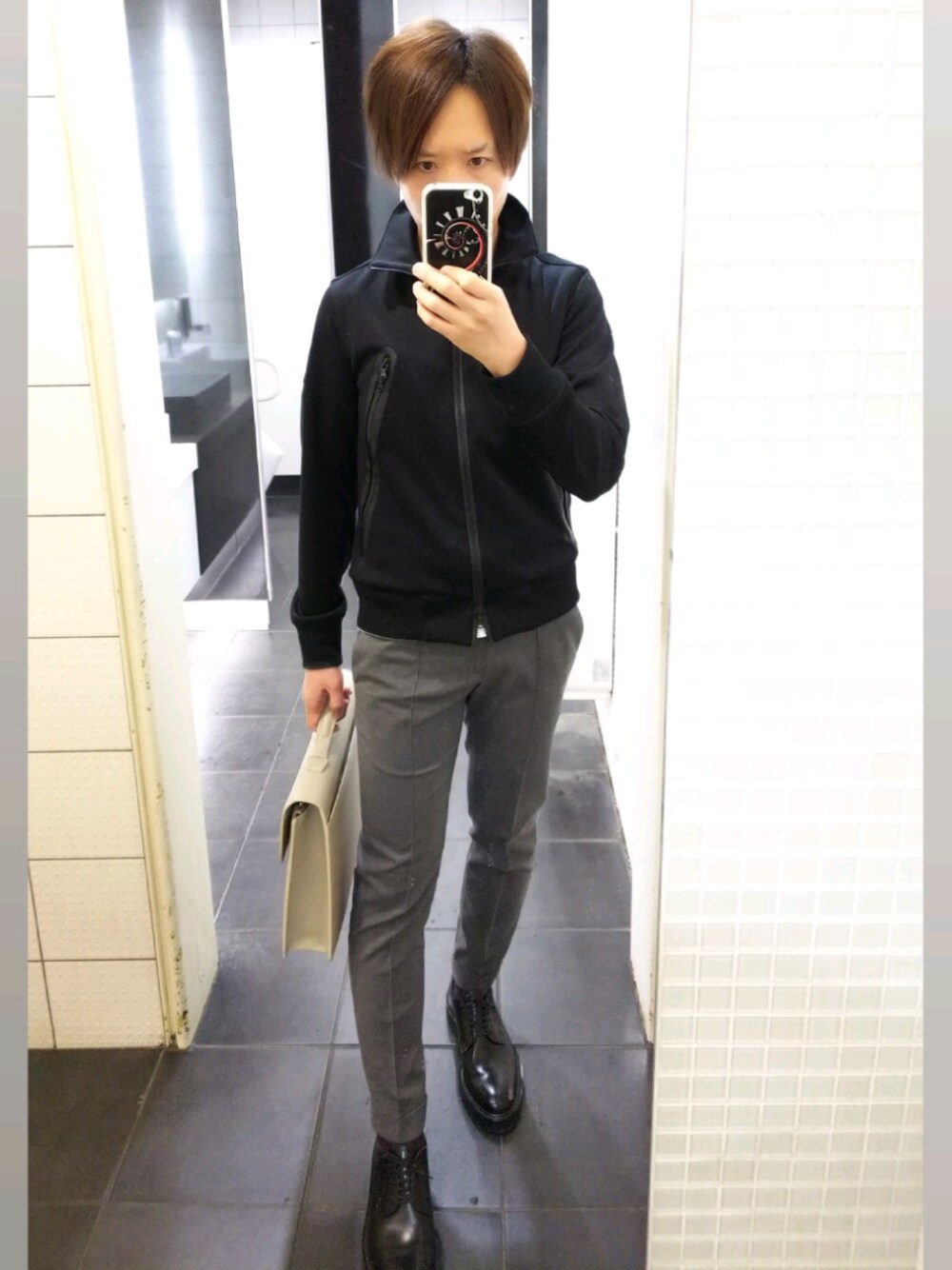 ブラック系のライダースジャケット、ブラック系のその他シューズ、グレー系のスラックスを着用したメンズの春コーディネートの1枚目の写真