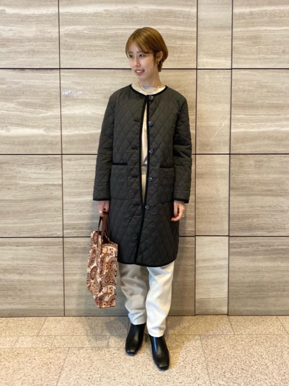 グレー系のニット/セーター、ブラック系のノーカラーコート、ホワイト系のその他パンツを着用したレディースの秋コーディネートの1枚目の写真