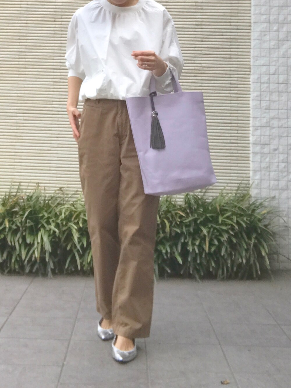 ホワイト系のトップス、パープル系のトートバッグ、ベージュ系のチノパンツを着用したレディースの春コーディネートの1枚目の写真