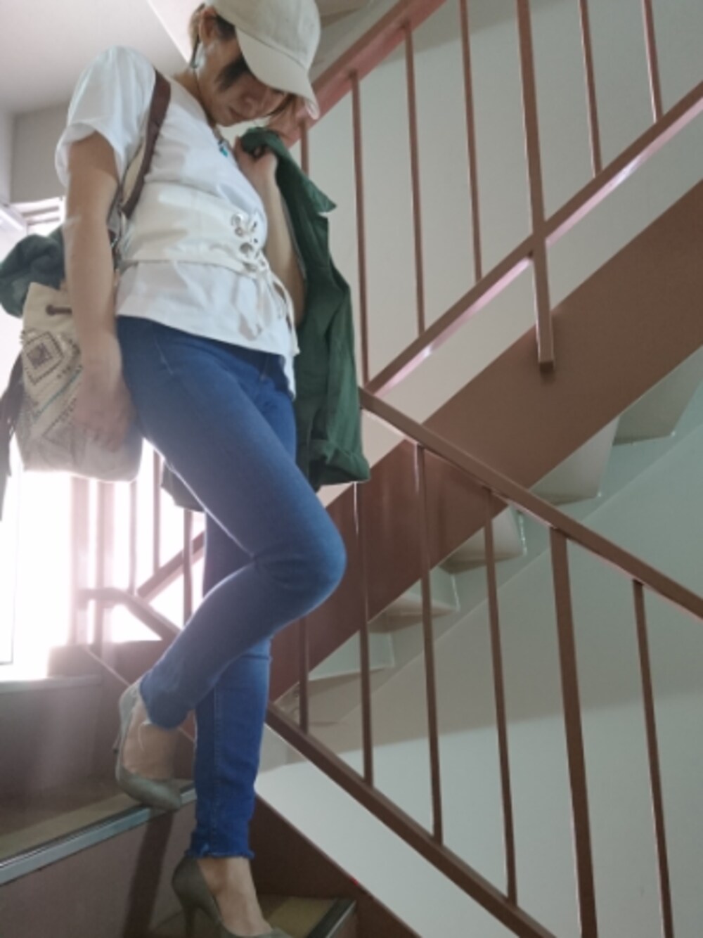 グリーン系のミリタリージャケット、ホワイト系のTシャツ/カットソー、ホワイト系のTシャツ/カットソーを着用したレディースの春コーディネートの1枚目の写真