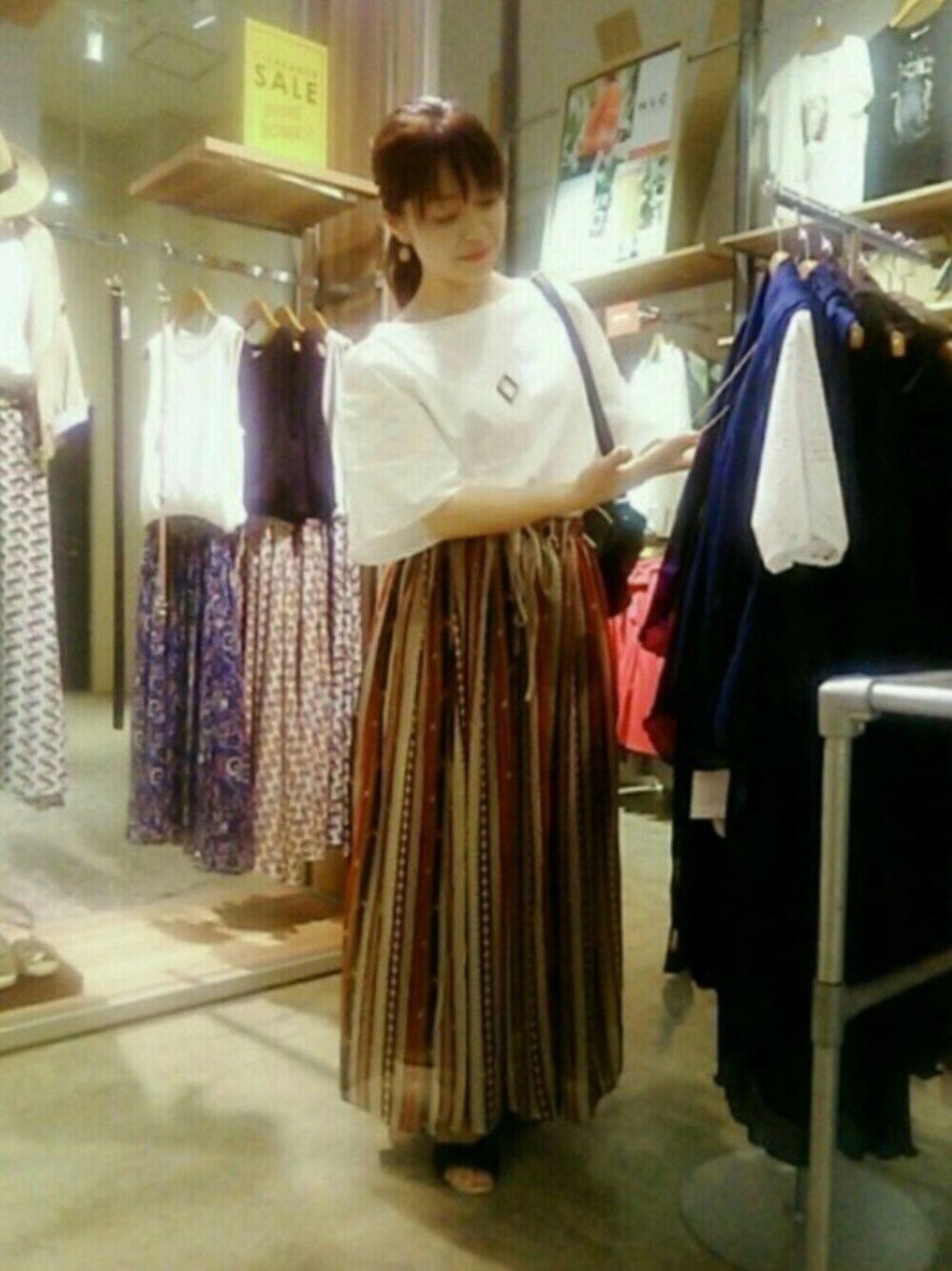 レッド系のスカート、ホワイト系のTシャツ/カットソーを着用したレディースの夏コーディネートの1枚目の写真