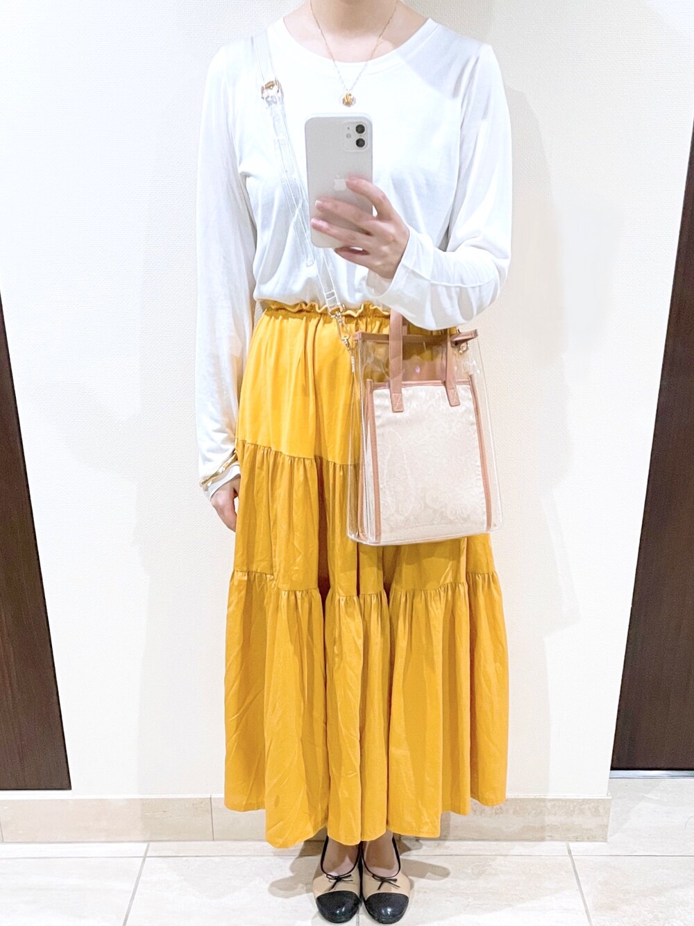 ベージュ系のレインシューズ、ベージュ系のショルダーバッグを着用したレディースの春コーディネートの1枚目の写真