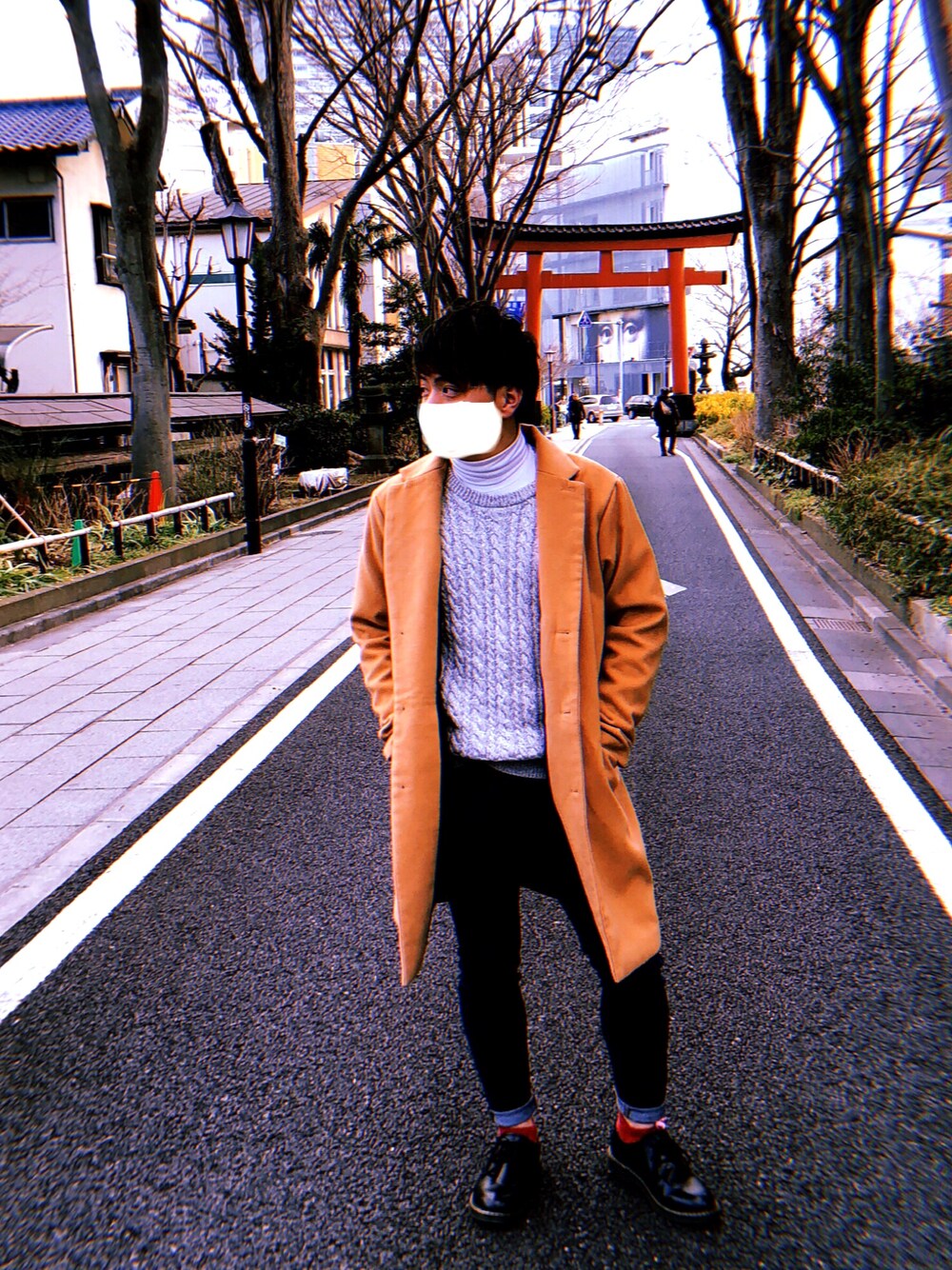 グレー系のニット/セーター、イエロー系のチェスターコート、ブルー系のパンツを着用したメンズの冬コーディネートの1枚目の写真