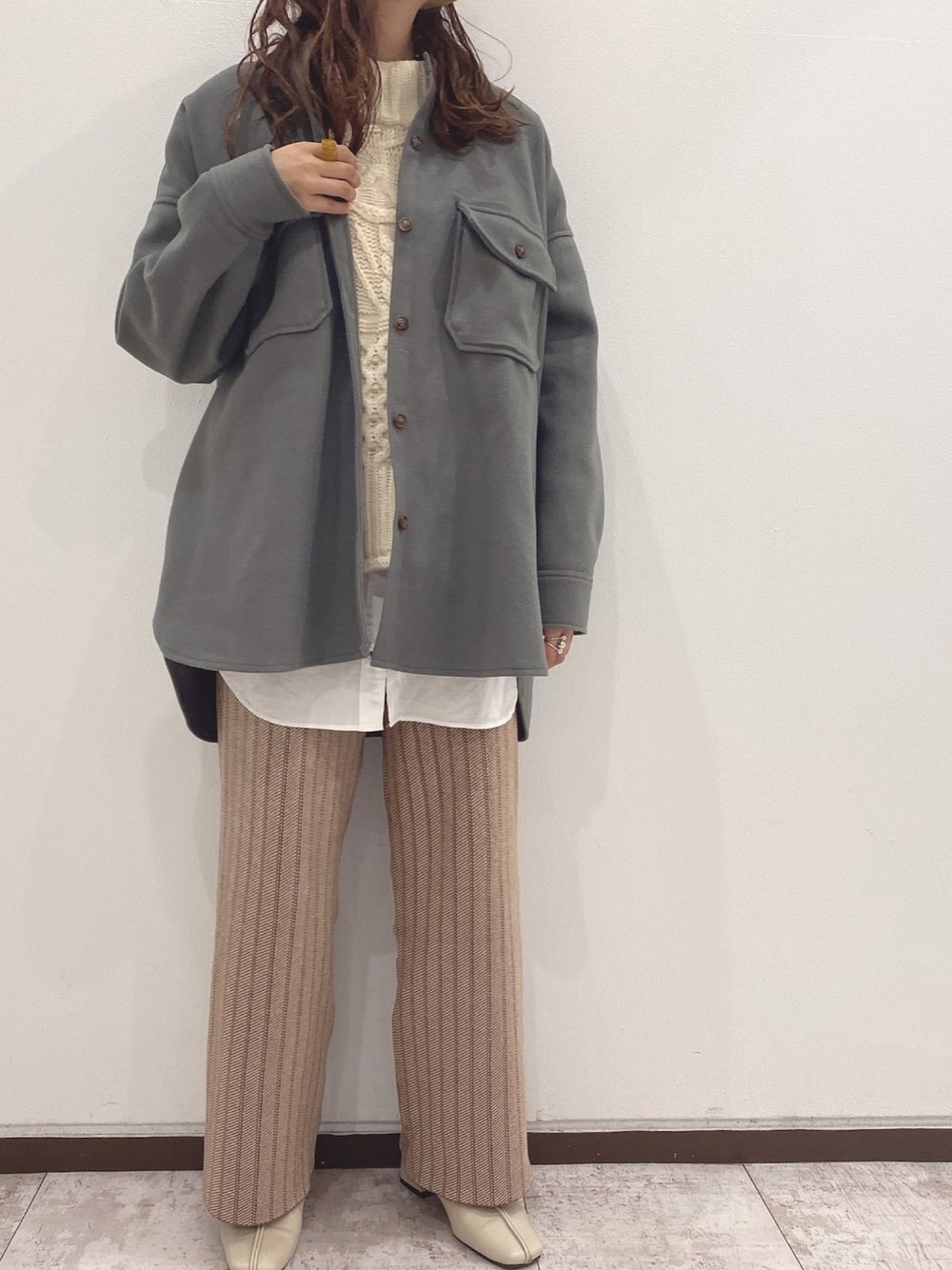 グレー系のカバーオール、ベージュ系のその他パンツ、ベージュ系のブーツを着用したレディースの冬コーディネートの1枚目の写真