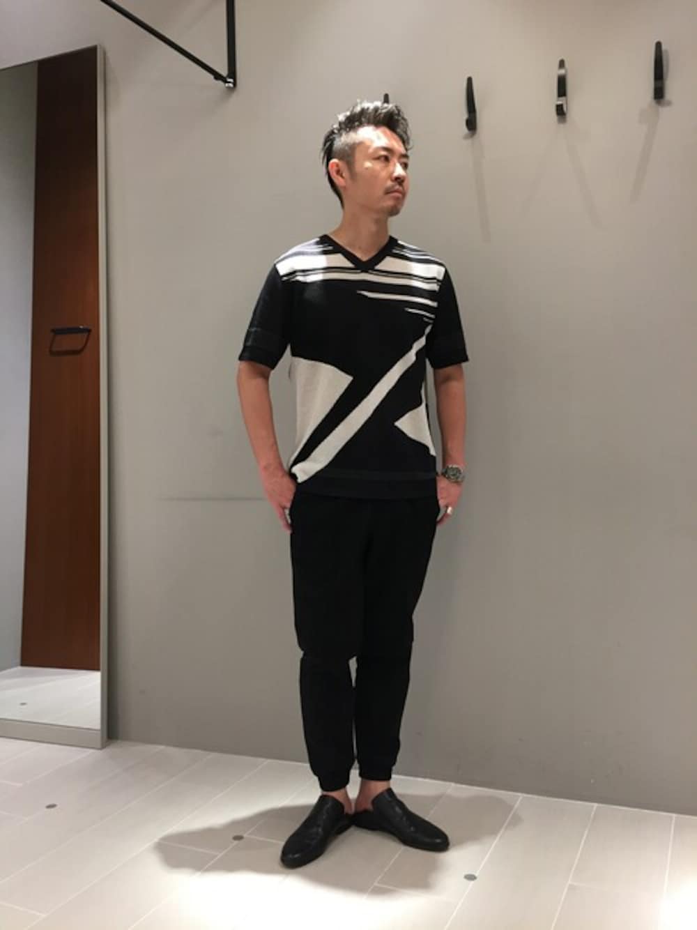 ブラック系のニット/セーター、ブラック系のその他パンツ、ブラック系のスリッポンを着用したメンズの夏コーディネートの1枚目の写真
