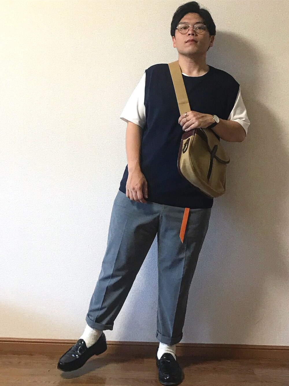 ブルー系のベスト、ホワイト系のTシャツ/カットソー、ベージュ系のショルダーバッグを着用したメンズの夏コーディネートの1枚目の写真