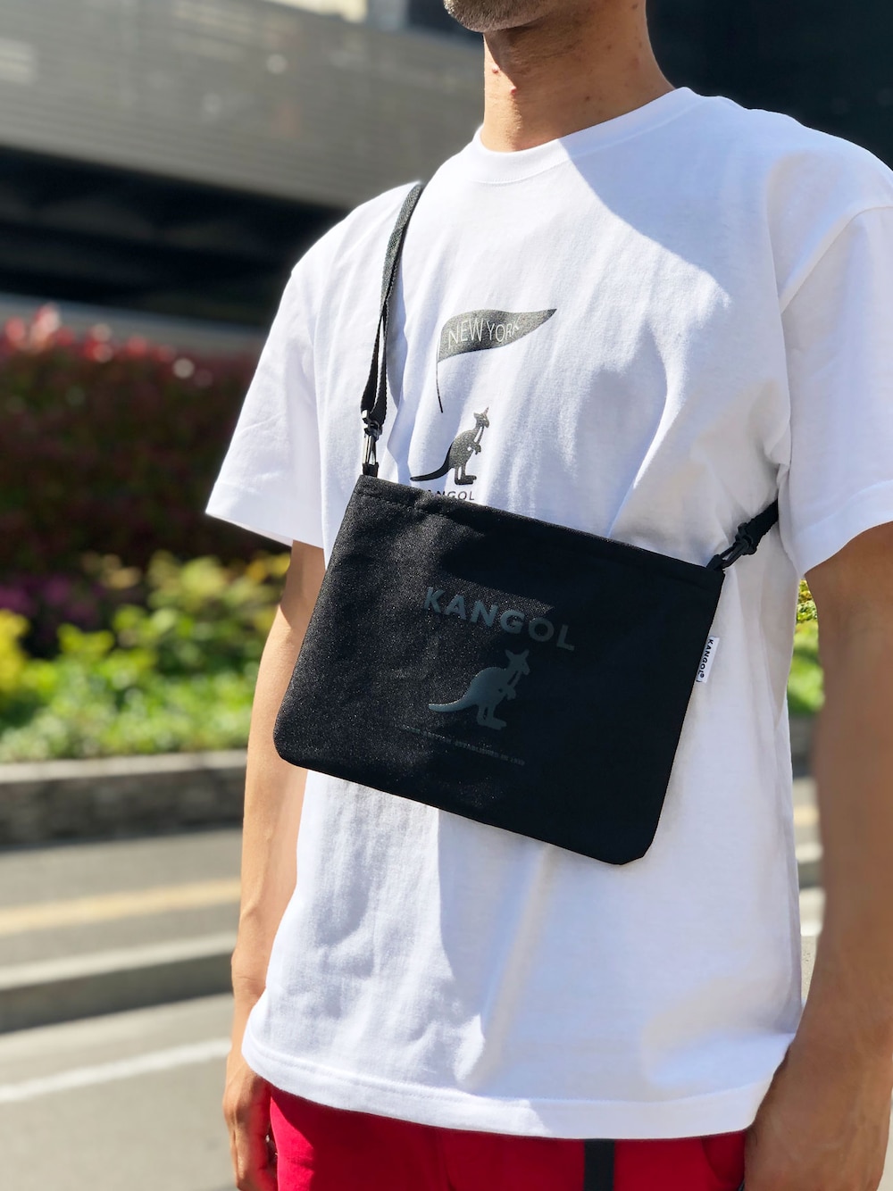 「ロゴT、ショルダーバッグ、ショルダーBAG、KANGOL、ショルダーバック、ロゴTシャツ、KANGOLDAY、サコッシュバッグ、サコッシュバック、サコッシュコーデ」｜「KANGOLの【KANGOL/カンゴール】 プリント サコッシュ / ショルダー ポーチ（ボディバッグ/ウエストポーチ、ブラック系）」を使った、Parks Tokyoさん（メンズ・175cm）の夏コーディネートの1枚目の写真