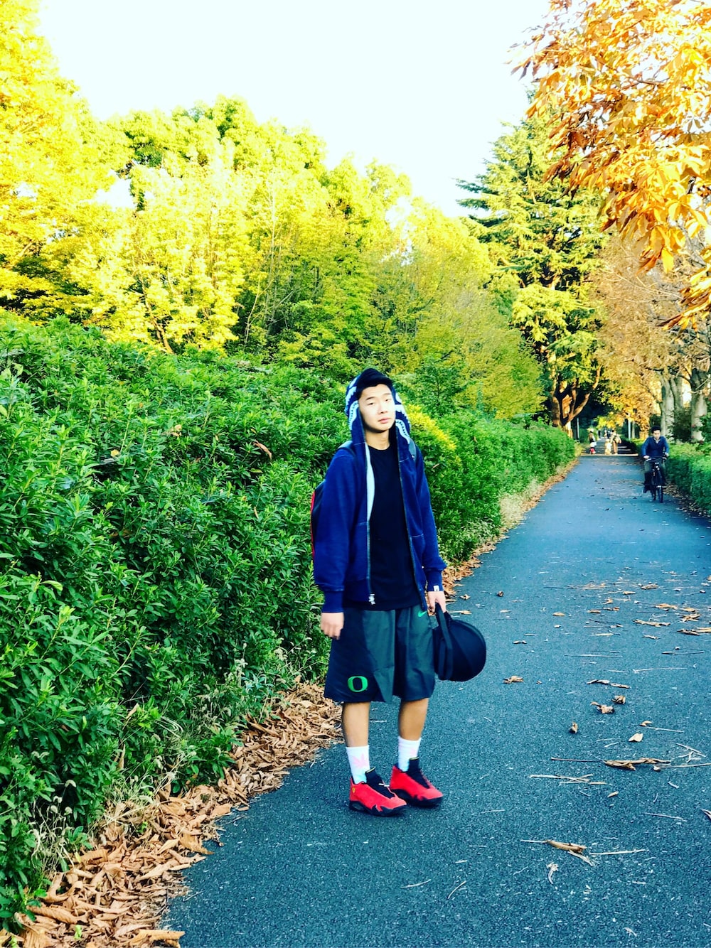 ブルー系のパーカー、グレー系のカーゴパンツ、レッド系のスニーカーを着用したメンズの冬コーディネートの1枚目の写真