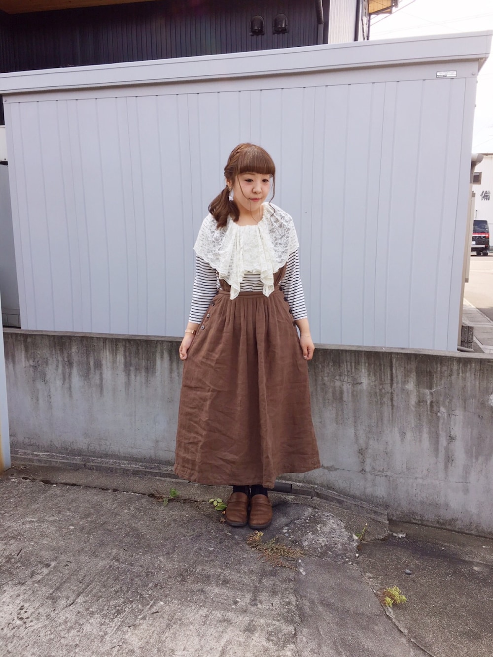 グリーン系のジャンパースカート、ホワイト系のタンクトップ、ブラウン系のシューズを着用したレディースの夏コーディネートの1枚目の写真