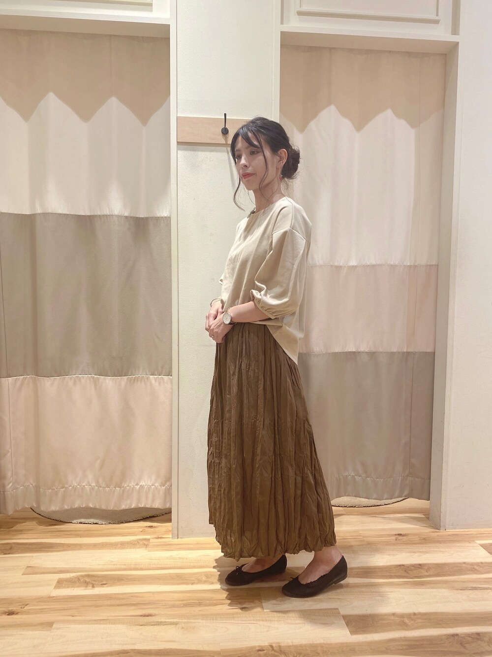 ベージュ系のTシャツ/カットソー、ブラウン系のスカートを着用したレディースの秋コーディネートの1枚目の写真