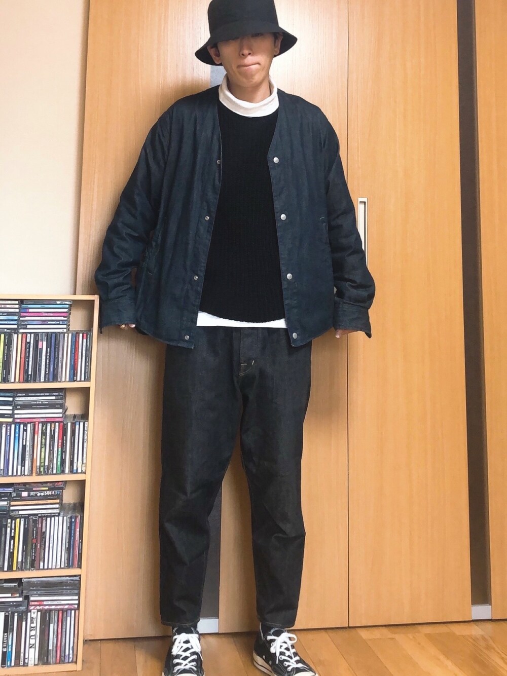 ブルー系のデニムジャケット、ブラック系のニット/セーター、ブラック系のデニムパンツを着用したメンズの冬コーディネートの1枚目の写真