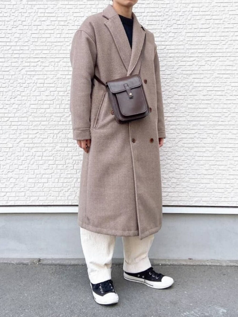 ブラック系のスニーカー、ホワイト系のその他パンツ、ベージュ系のチェスターコートを着用したメンズの冬コーディネートの1枚目の写真