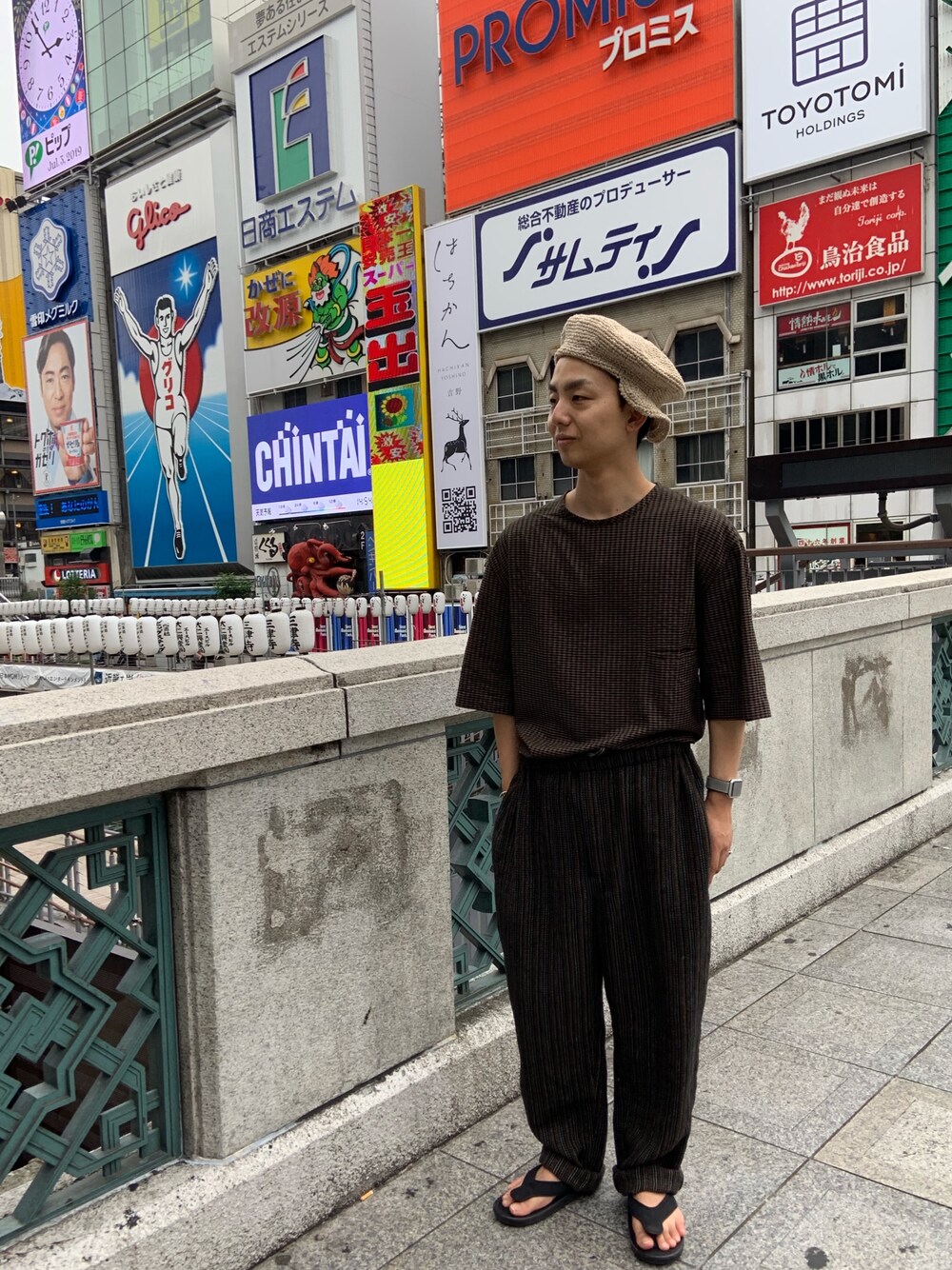 ブラウン系のTシャツ/カットソー、ブラック系のスラックスを着用したメンズの夏コーディネートの1枚目の写真