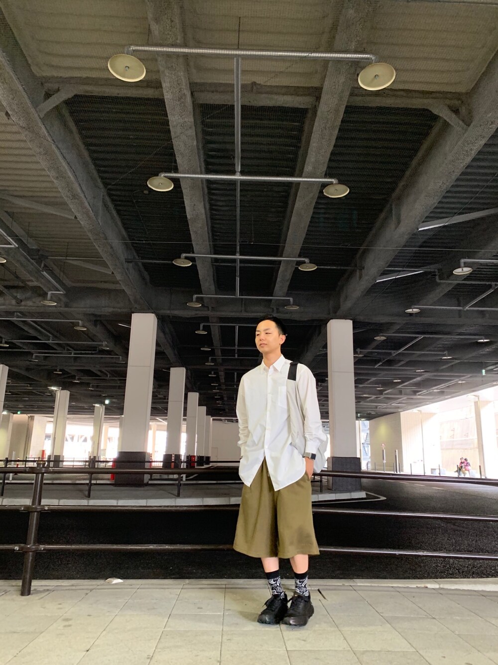 ホワイト系のトップス、グリーン系のパンツを着用したメンズの夏コーディネートの1枚目の写真