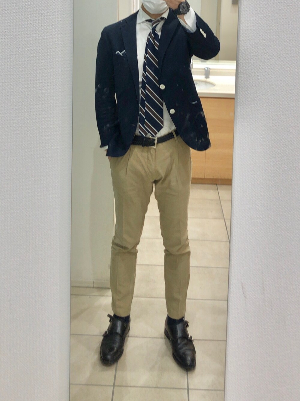 ブルー系のネクタイ、ベージュ系のパンツを着用したメンズの春コーディネートの1枚目の写真