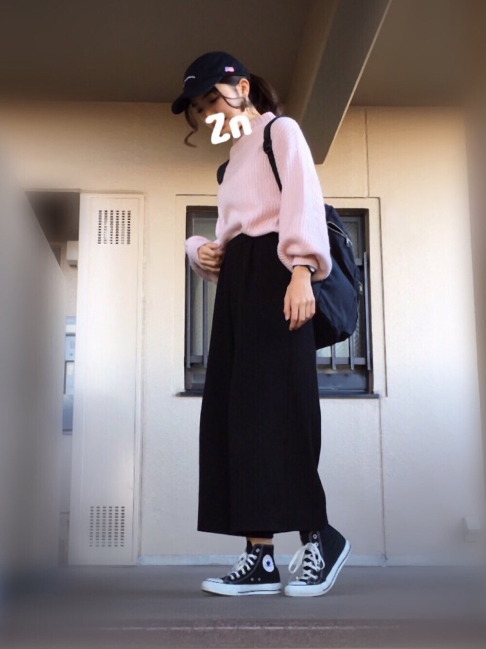ピンク系のニット/セーター、ブラック系のその他パンツ、ブラック系のバックパック/リュックを着用したレディースの冬コーディネートの1枚目の写真