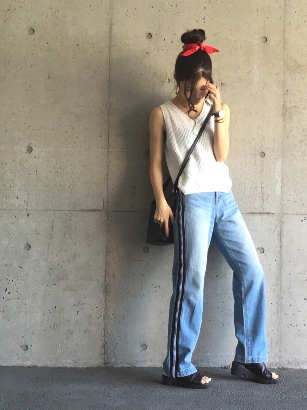 ホワイト系のベスト、ブルー系のデニムパンツ、ブラック系のショルダーバッグを着用したレディースの夏コーディネートの1枚目の写真