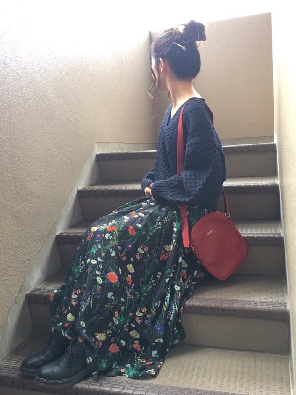 ブルー系のニット/セーター、ブラック系のスカート、レッド系のショルダーバッグを着用したレディースの秋コーディネートの1枚目の写真