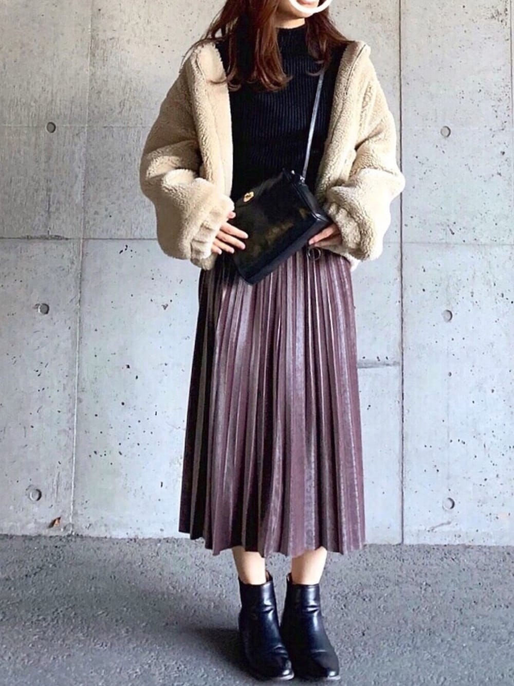 ブラウン系のスカート、ベージュ系のその他アウター、ブラック系のニット/セーターを着用したレディースの冬コーディネートの1枚目の写真